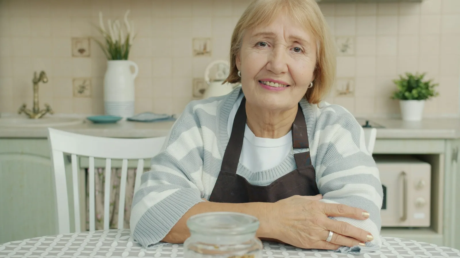 Smiling senior woman sitting at a kitchen table